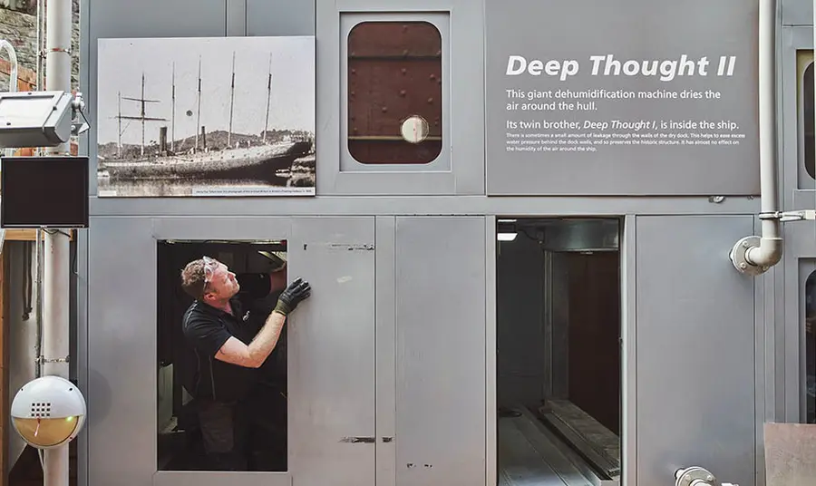 A worker refits the dehumidifying equipment that conserves the SS Great Britain.