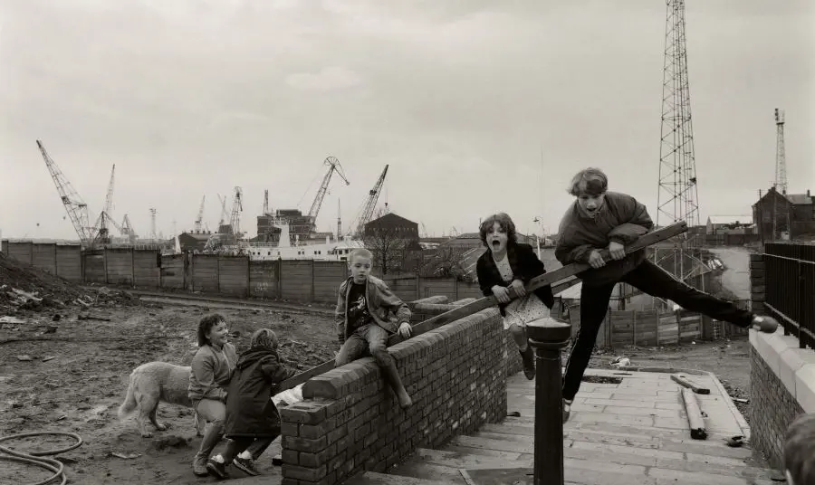 Step by Step from the Amber Collection A black and white image of children playing in an industrial area.