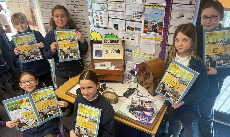 School pupils learned about the Second World War as part of outreach activities at The Hold. A group of school children hold books about life during the second world war and pose around a display related to the second world war