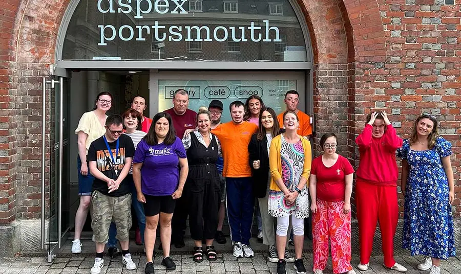 A group of people posing for the camera in front of the Aspex gallery in Portsmouth