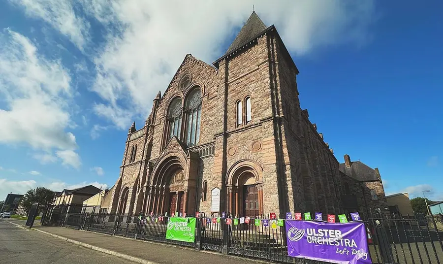 the exterior of a large stone church on a street