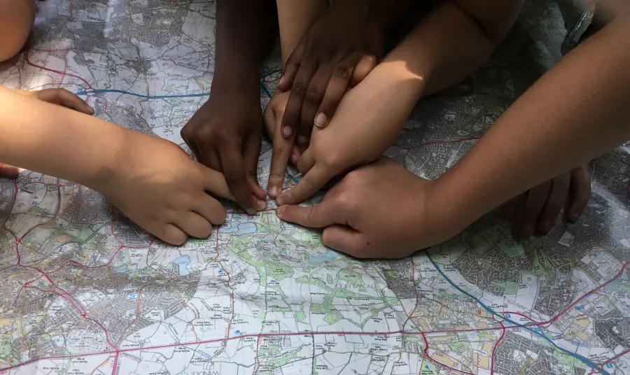 Photograph of hands pointing at a map