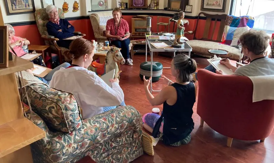 A group of different ages discuss nostalgic objects in the Wee Museum of Memory.