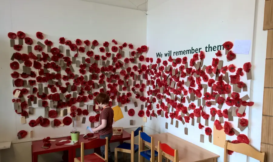 A young visitor adds to the poppy wall of remembrance at Worcester City Art Gallery and Museum