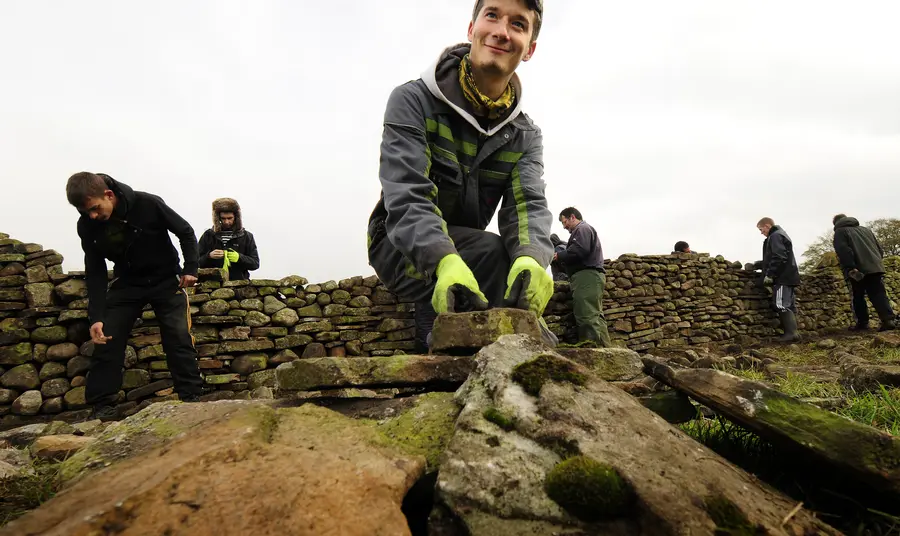 A trainee working on a dry stone wall