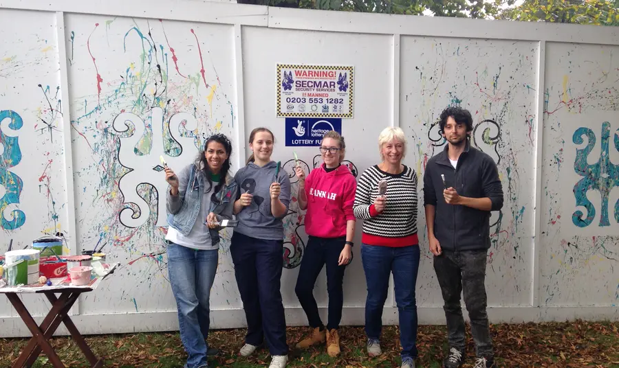 Five young volunteers with paintbrushes