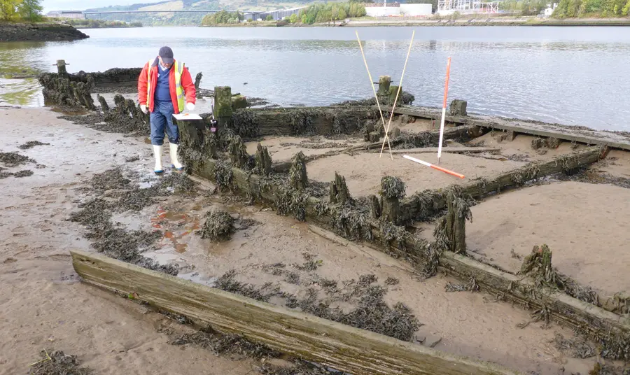 A volunteer surveys the wreckage of a boat
