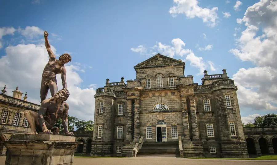 Seaton Delaval Hall, a baroque manor house flanked by elaborate stone statues