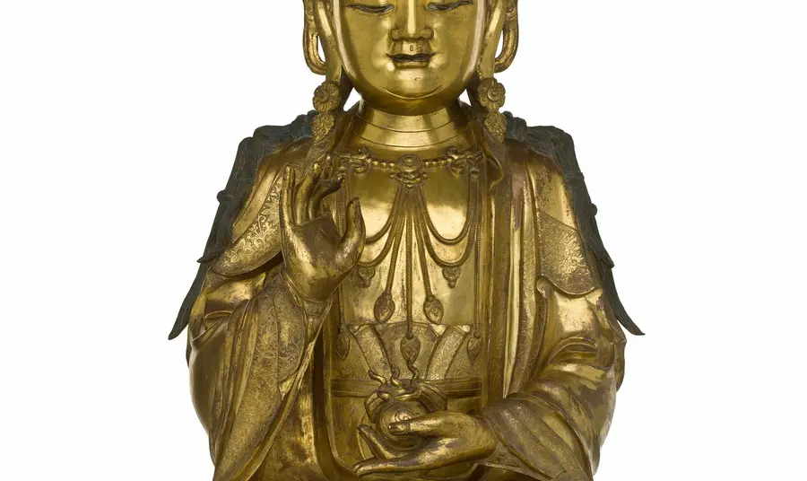 Figure of a bodhisattva in gilt bronze, holding a flaming jewel in left hand