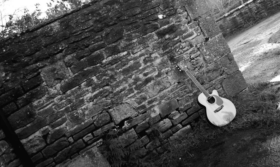 Gitâr Noel Gallagher yn pwyso yn erbyn wal yn Stiwdios Rockfield