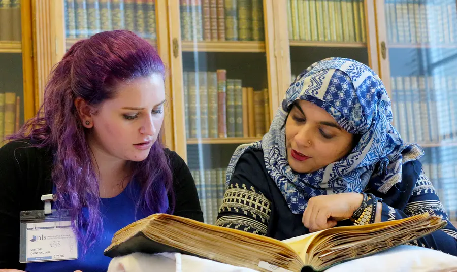 Two ladies reading a book