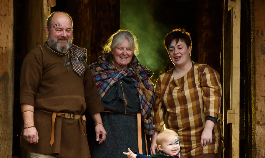 A family group in Iron Age dress in the doorway of the round House
