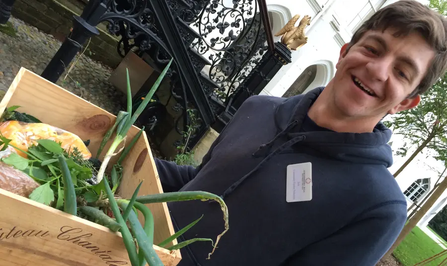 Jack, volunteer at Strawberry Hill, carrying vegetable grown in the garden