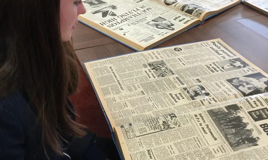 A student reads about the punk scene in old copies of the Portsmouth News