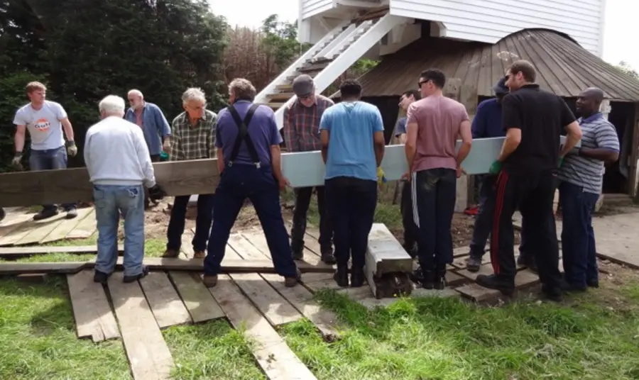 People restore a windmill