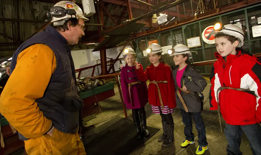A man teaches school children about mining heritage at the Big Pit National Mining Museum of Wales