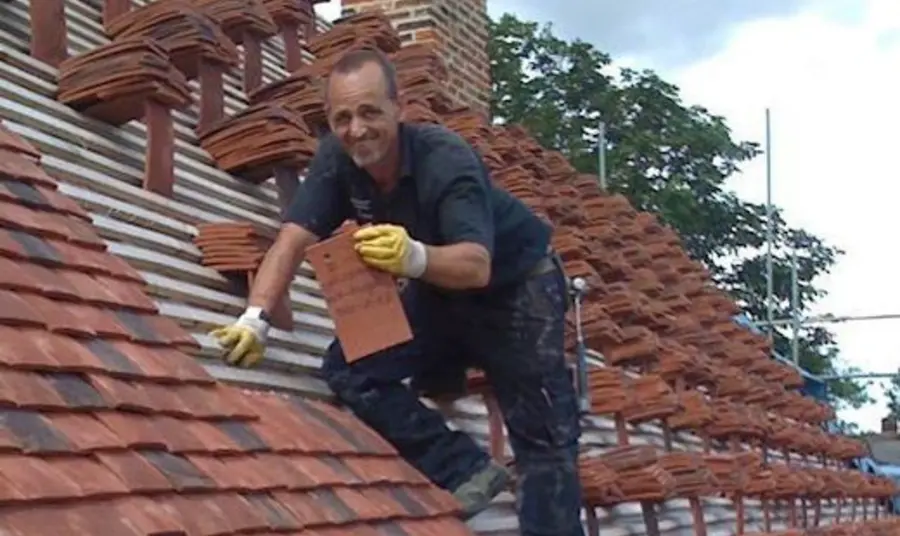Finchingfield Guildhall A man retiling the roof at Finchingfield