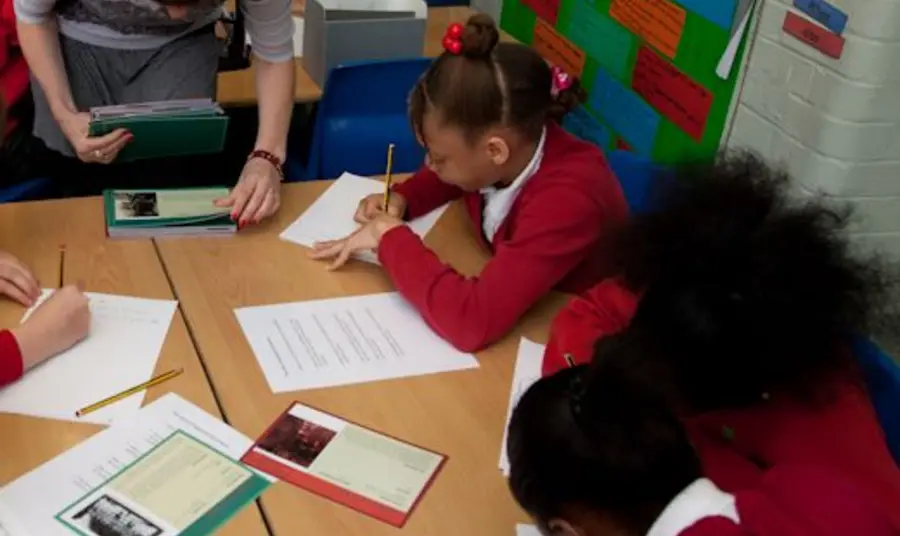 School children look at First World War sources in a classroom