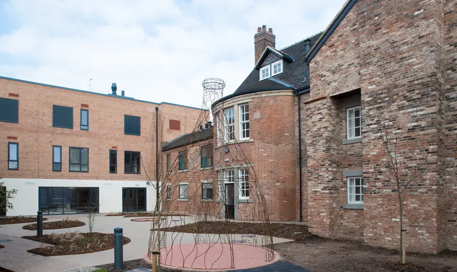 The courtyard of the belong heritage gallery An old two-story brick building surrounds a paved courtyard