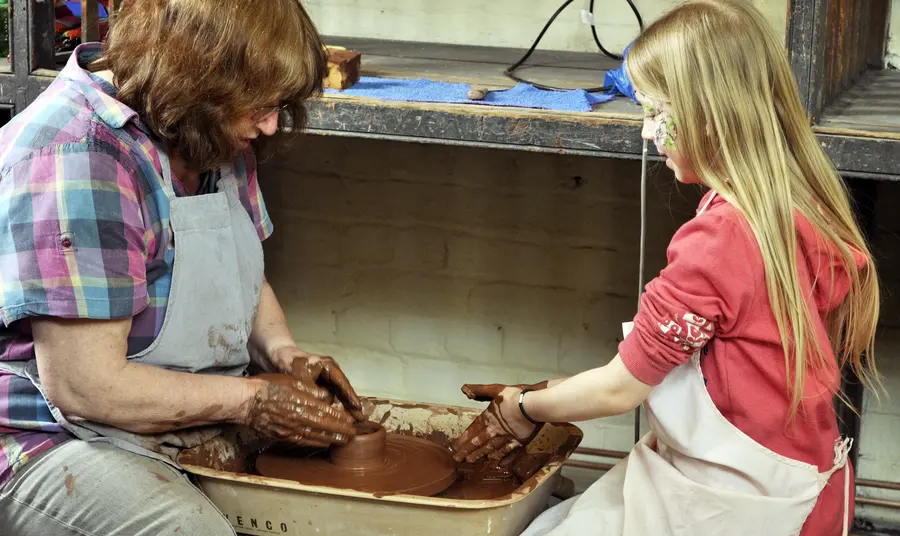 A woman and girl try pottery