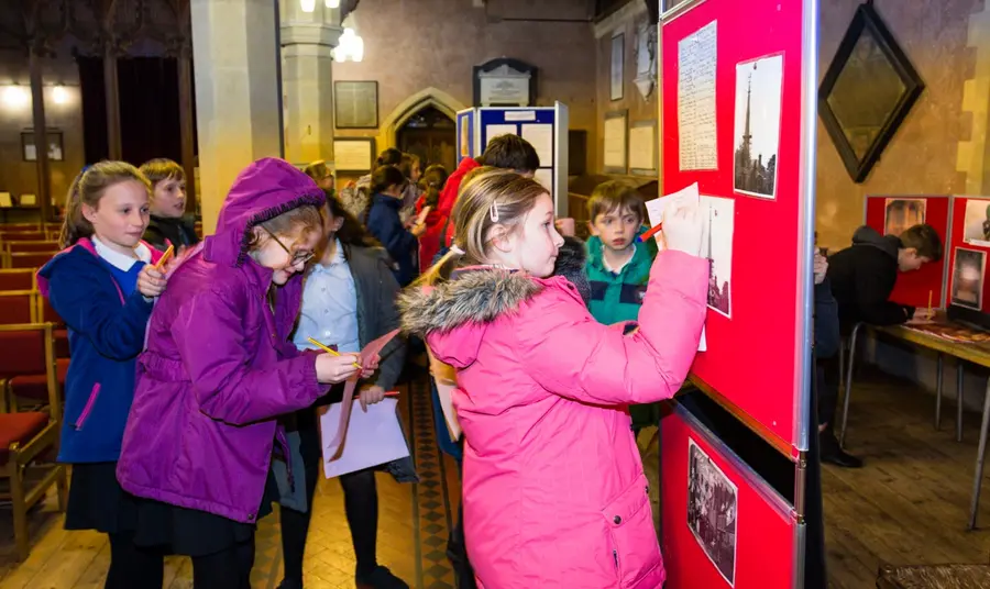 A group of school pupils make notes while taking part in a church trail