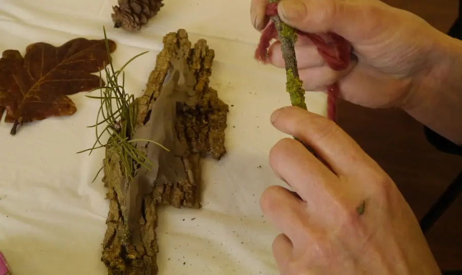 Participant feeling a piece of bark along with other items from the natural environment