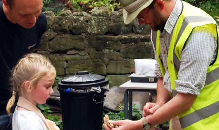 An archaeologist showing his findings to local families