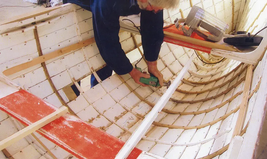 A volunteer working on boat restoration