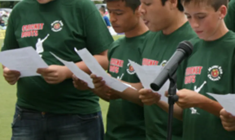 Young people performing a song at a cricket match