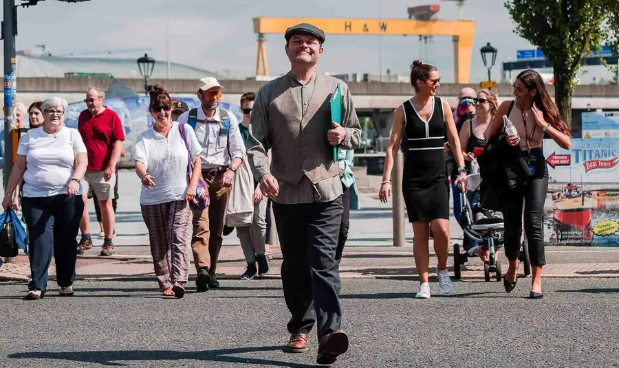 A tour group walking around Belfast's docklands on a sunny day