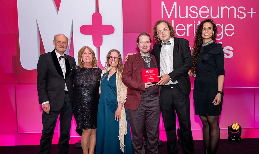A group of people posing with an award
