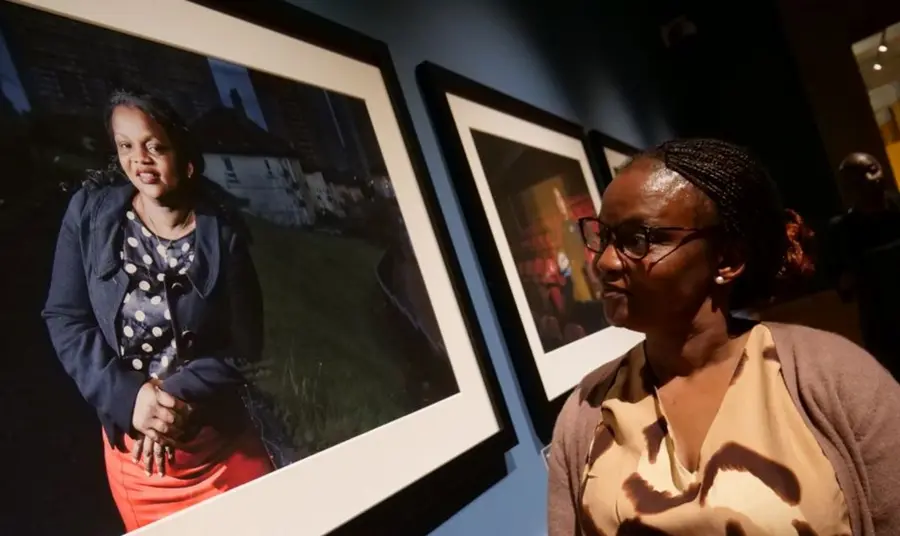 Twimukye Mushaka smiles whilst looking at a portrait of herself on display.