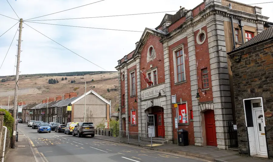 The Tylorstown Welfare Hall sits at the heart of the local community. Tylorstown Welfare Hall stands out as the largest building on a street of traditional terraced houses, with the valley side in the background.