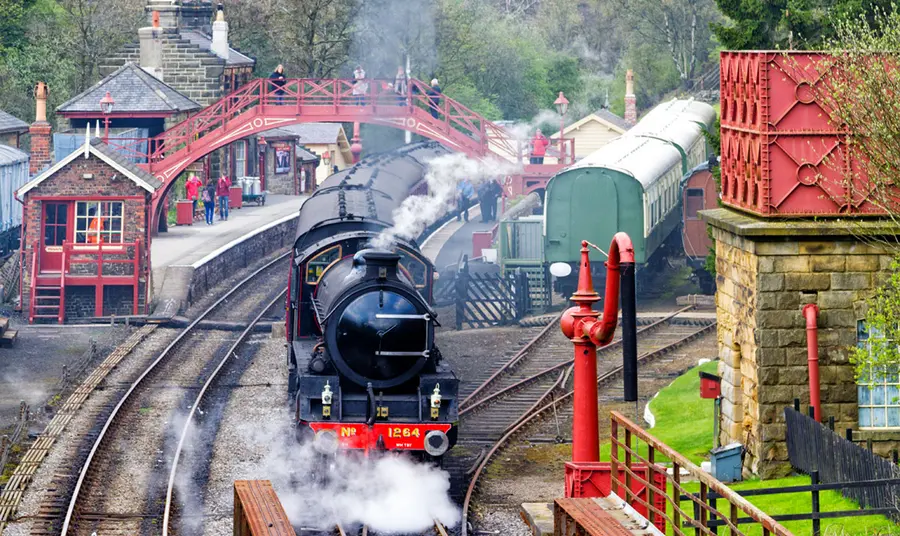 A train with steam coming out of it at North York Moors Railway.