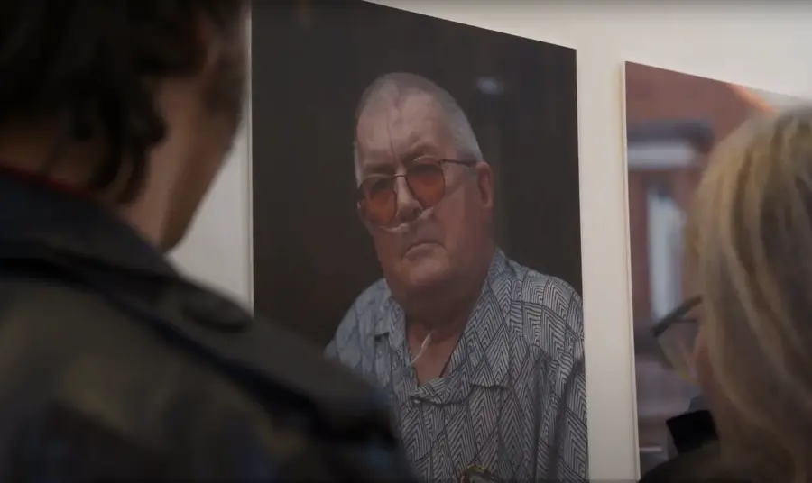 Two people look at an exhibition of photos of LGBTQ+ people from the Isle of Wight.