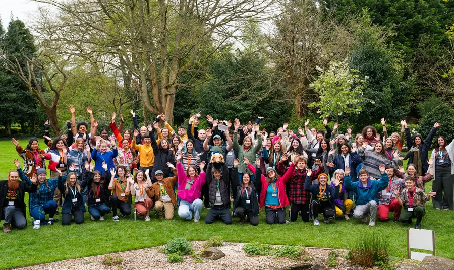 A large group of young people cheering outdoors