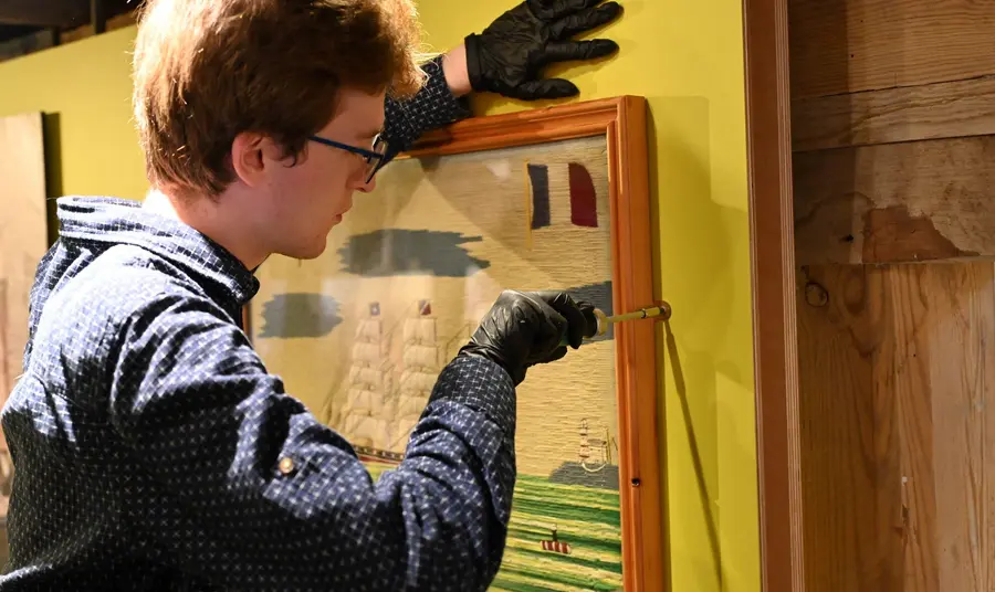 A person installing a exhibit at Poole Museum