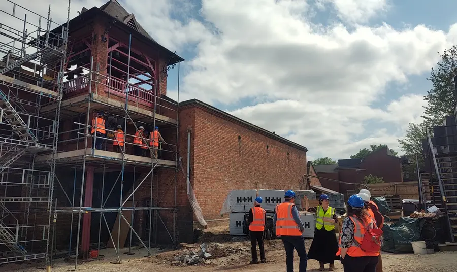 A tour group in high-vis and hard hats explore the exterior of the Bellfoundry during its conservation.