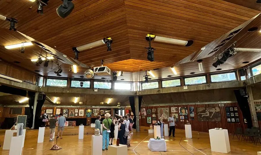 The hexagonal school hall building with visitors inside.