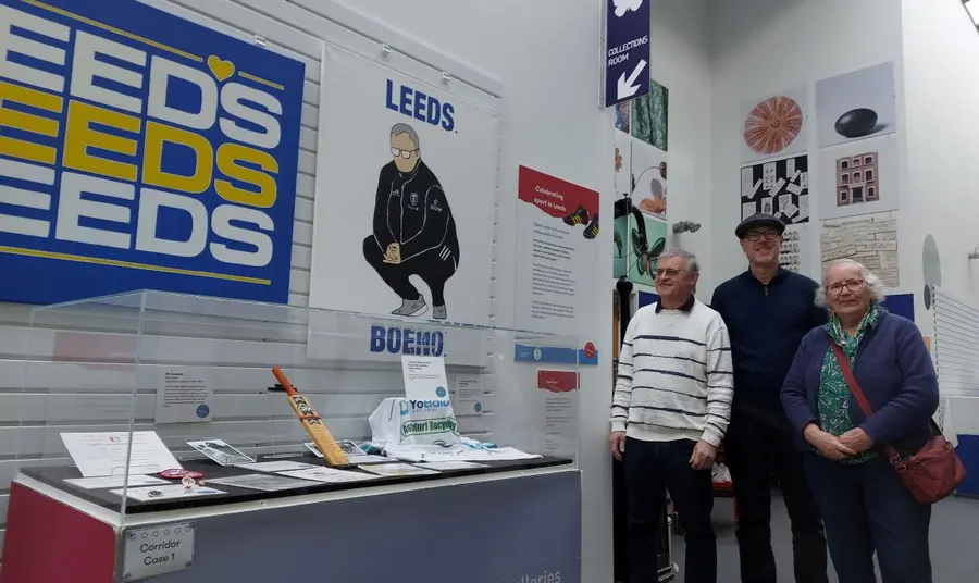 Learning about the city's sporting heritage. Visitors exploring a gallery featuring posters of Leeds's sporting history and glass cases of artefacts.