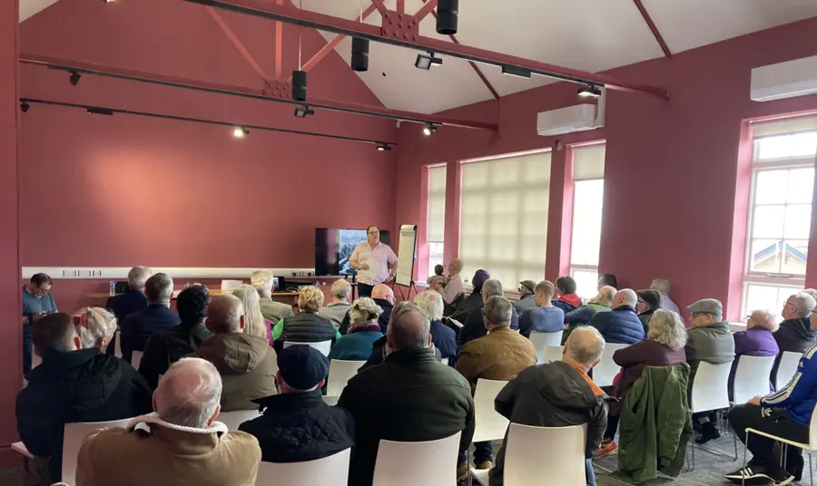 Frankie Quinn stands in front of a full hall of people at a project engagement day.