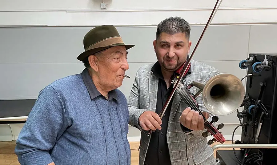 Two performers play a horn violin and a whistle