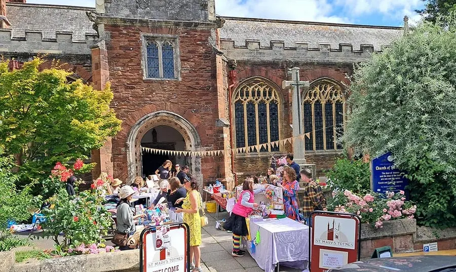 a market outside a historic brick church in summer