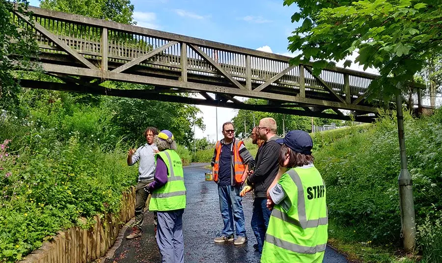 Community members in hi vis working in nature.