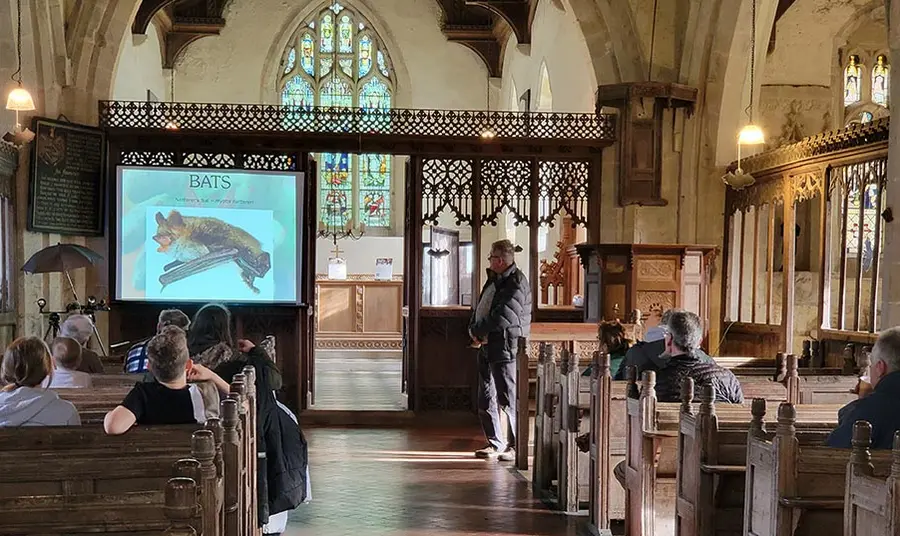 A person gives a talk about bats in a church