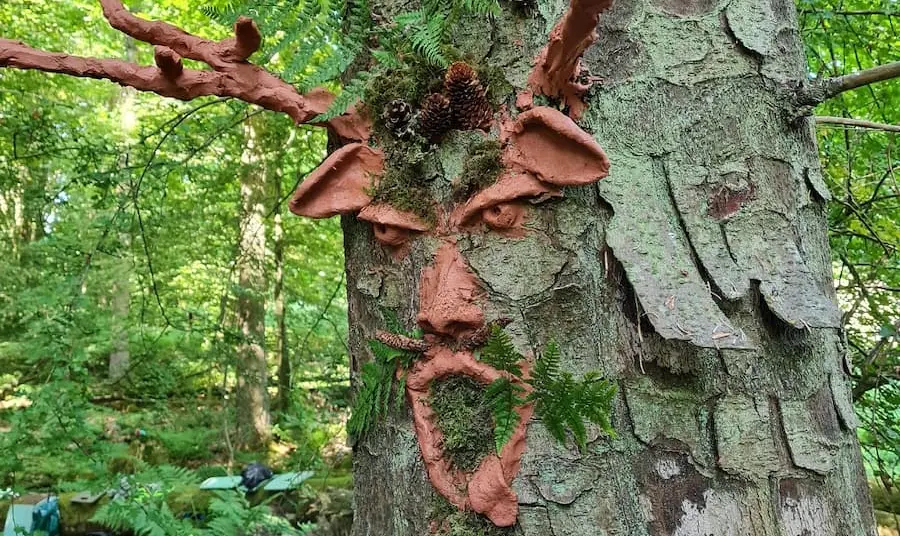 Clay art face on a tree