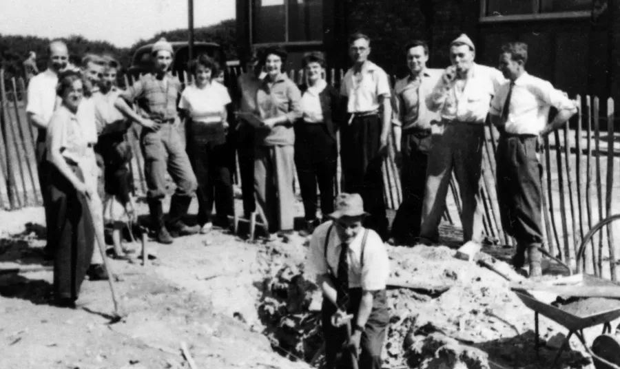 a black and white photograph of archaeologists on a dig site