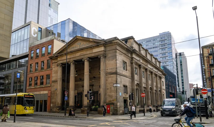The outside of the 19th-century building with a large stone portico supported by columns