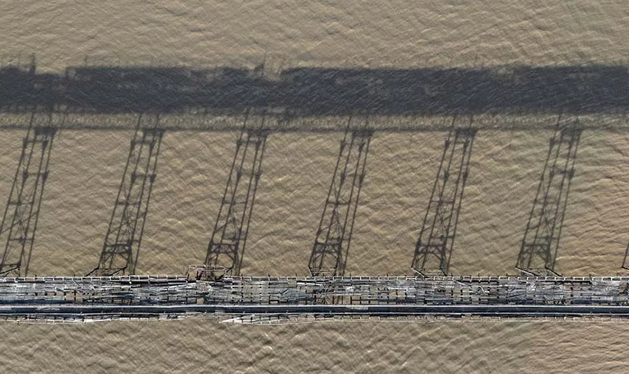 The bridge of Birnbeck Pier in a state of disrepair among the water.