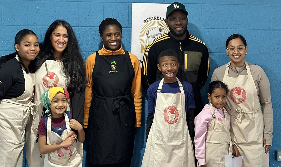 A group of children and young people wearing aprons with the Rekindle logo